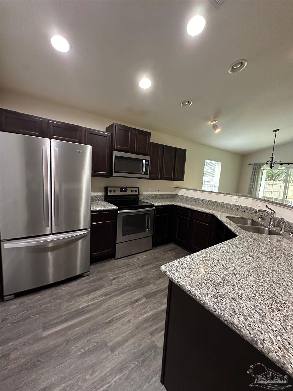 5933 Fairlands Road Milton, FL 32583 - Photo 4 of 16 a kitchen with stainless steel appliances granite countertop a sink stove and refrigerator