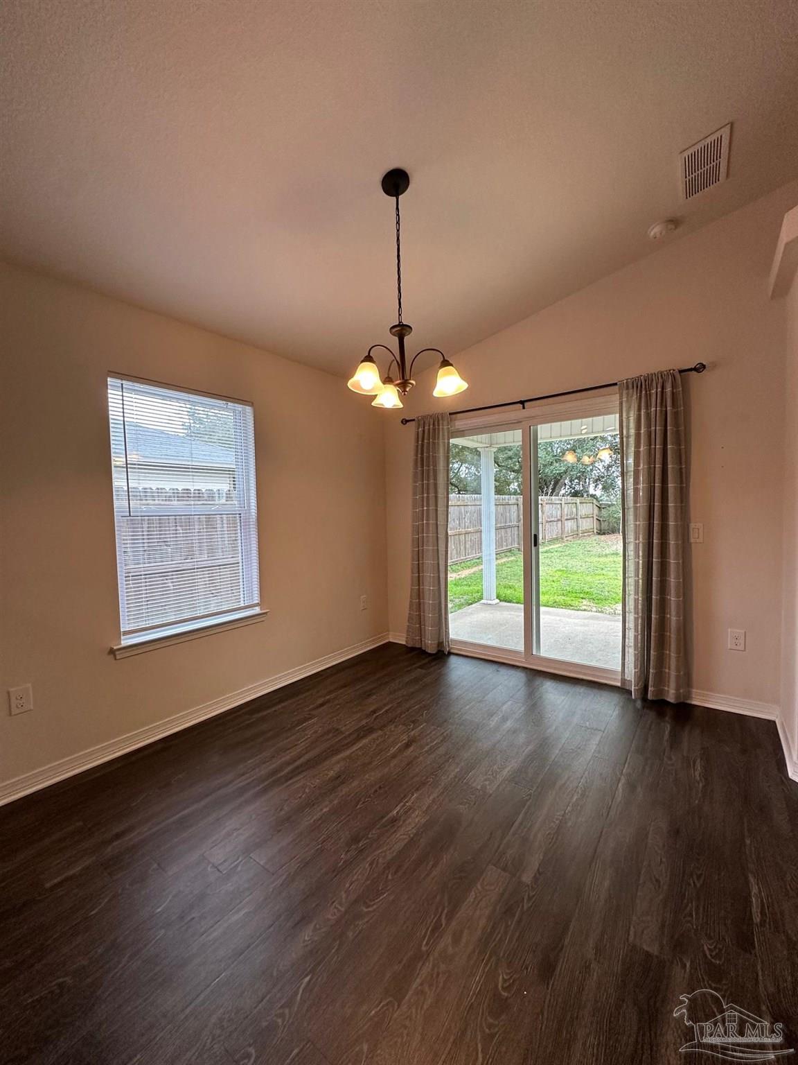 5933 Fairlands Road Milton, FL 32583 - Photo 5 of 16 a view of an empty room with wooden floor and a window