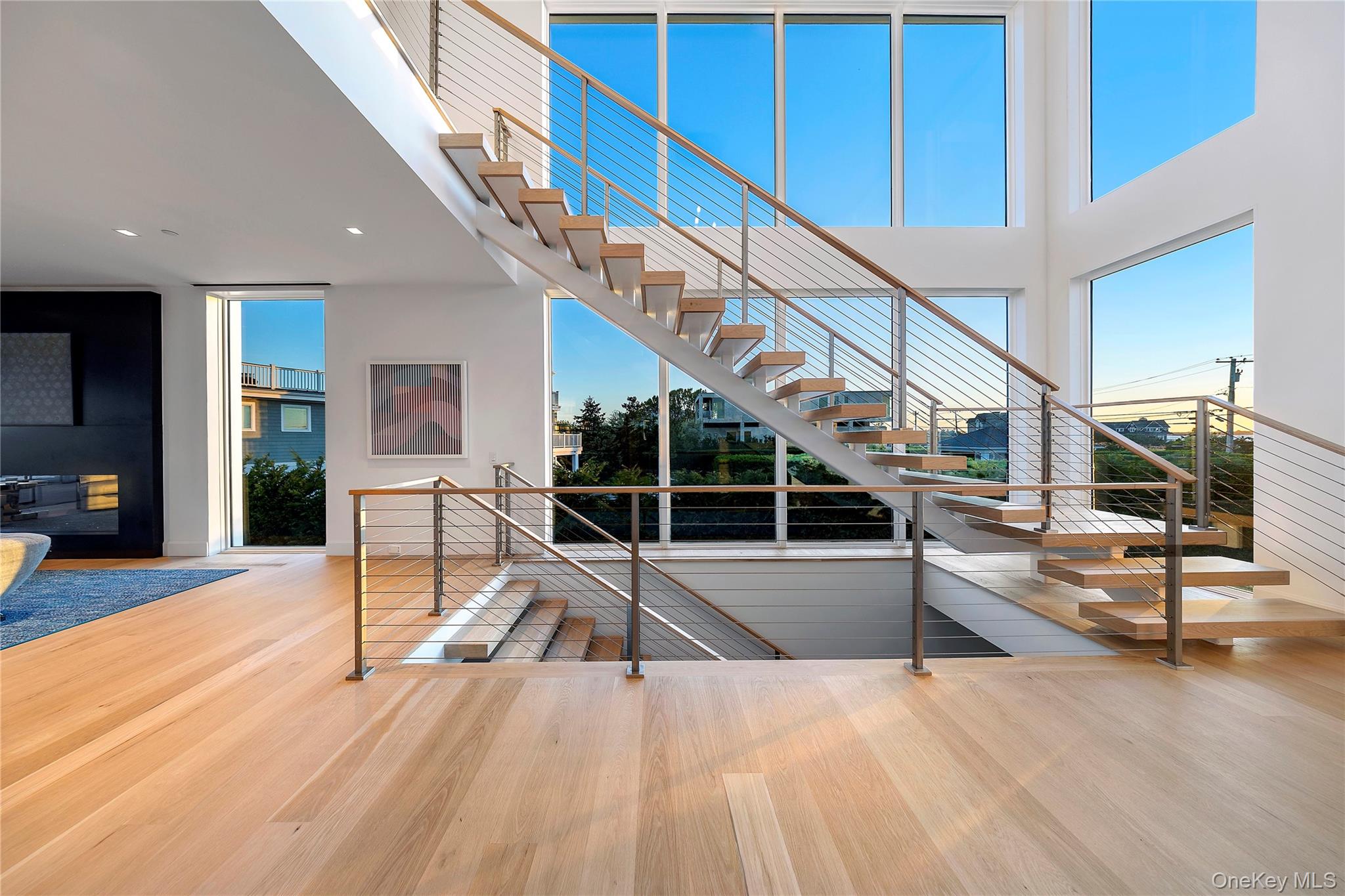 345 Dune Road Westhampton Beach, NY 11978 - Photo 13 of 34 Stairs featuring wood finished floors, a high ceiling, and recessed lighting
