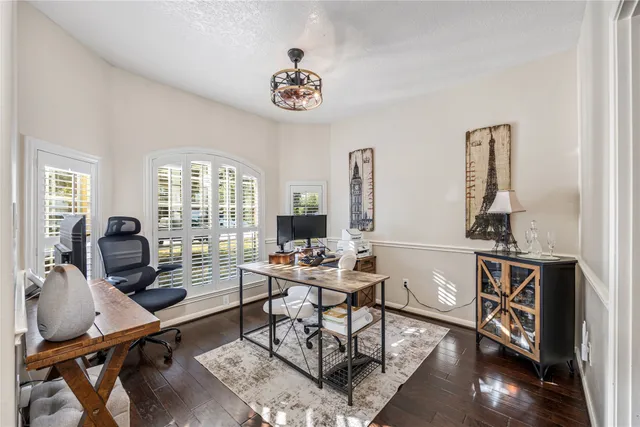 a kitchen with stainless steel appliances granite countertop a stove top oven a sink dishwasher a refrigerator and white cabinets with wooden floor