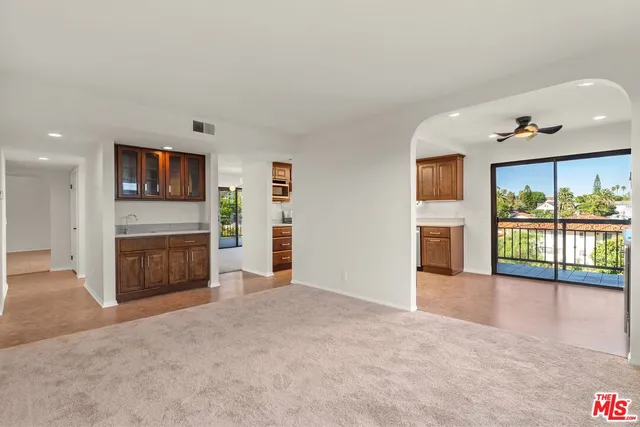 an empty room with furniture and a floor to ceiling window