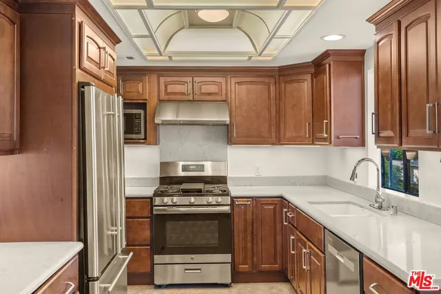 a kitchen with stainless steel appliances a stove a sink and a refrigerator