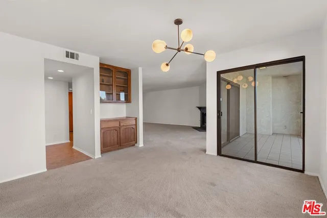 a view of a chandelier fan and refrigerator in a room