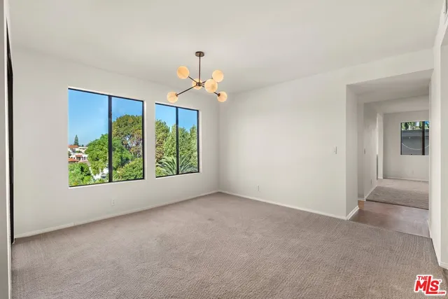 an empty room with windows and chandelier