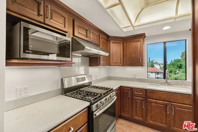 a kitchen with stainless steel appliances granite countertop a stove and a microwave