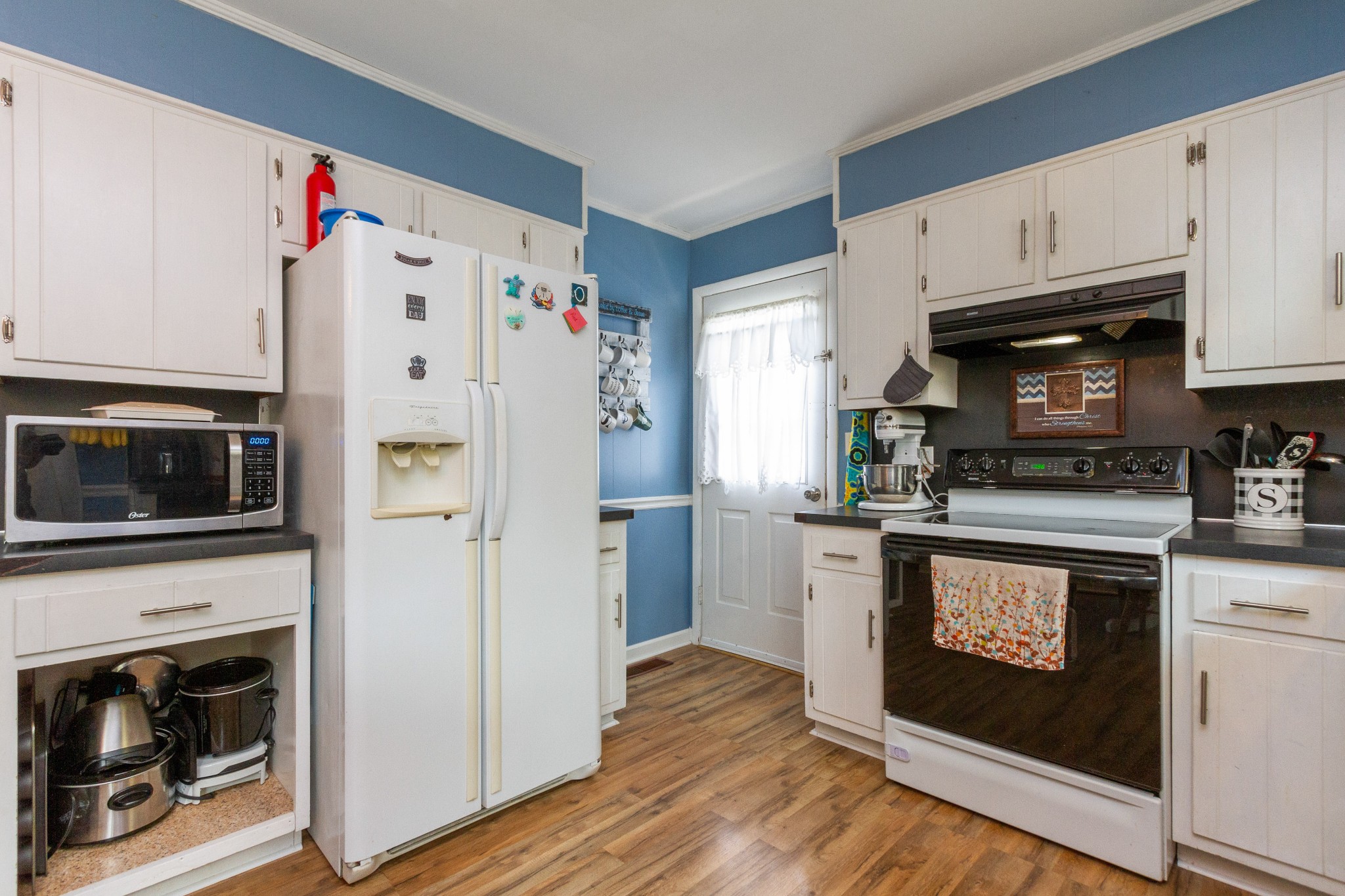 1940 Austin Road Lafayette, TN 37083 - Photo 21 of 41 a kitchen with stainless steel appliances white cabinets and a stove top oven
