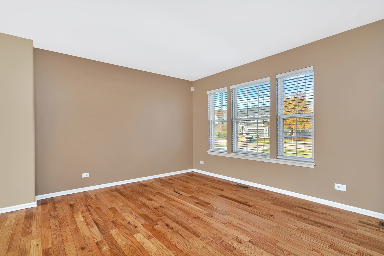 2509 Rosehall Lane Aurora, IL 60503 - Photo 8 of 51 a view of an empty room with wooden floor and a window