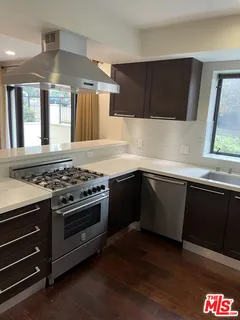 a kitchen with granite countertop a stove and a sink