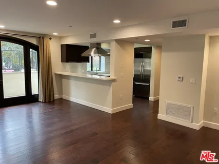 a view of kitchen with stainless steel appliances wooden floor and large window