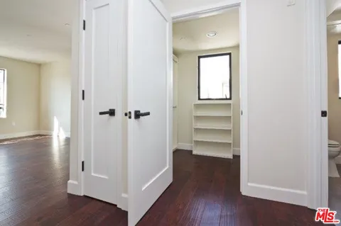 a view of a hallway with wooden floor and closet