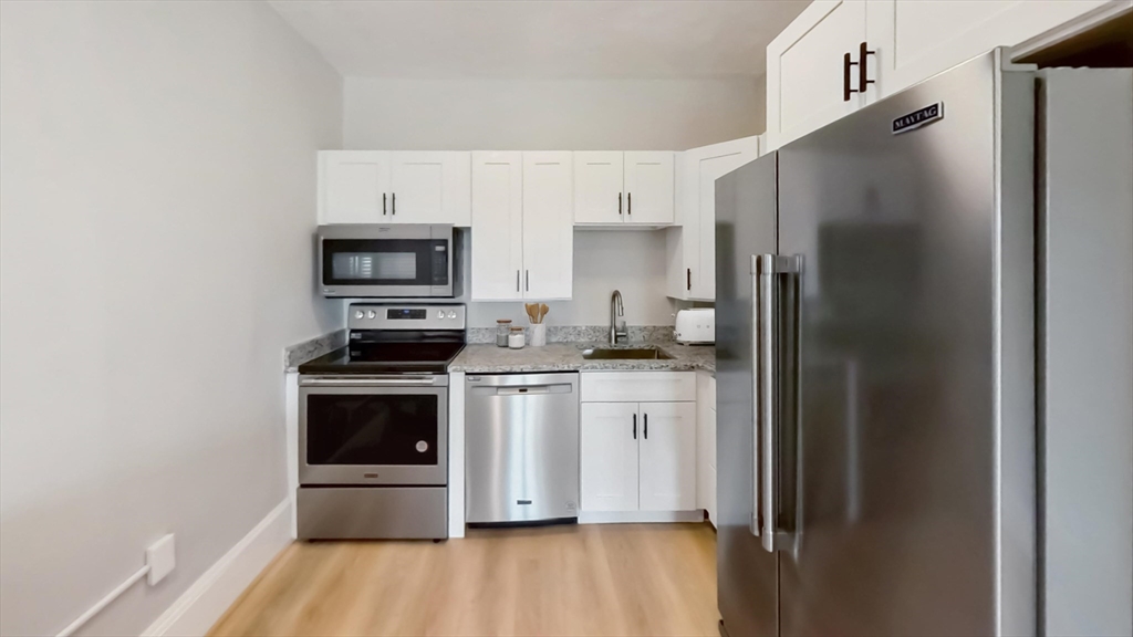 a kitchen with stainless steel appliances a refrigerator stove and microwave