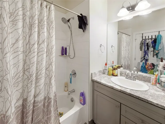 a bathroom with a granite countertop sink a shower and a mirror