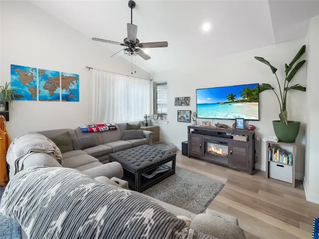 a living room with furniture a flat screen tv and a fireplace