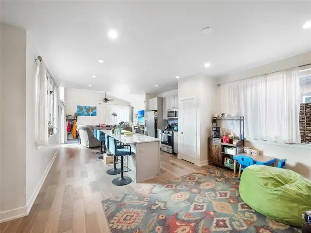 a living room with furniture and a dining table with kitchen view