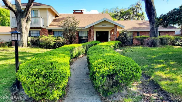 a front view of a house with a garden and plants