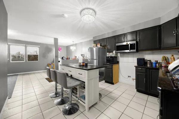 a kitchen with stainless steel appliances kitchen island granite countertop a refrigerator and a stove top oven