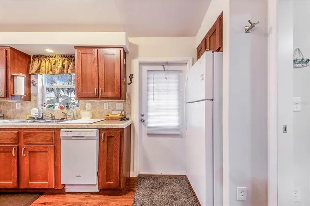 a kitchen with granite countertop a refrigerator and a stove top oven