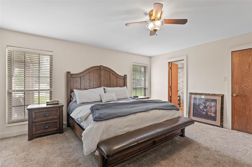108 Carlin Road Mansfield, TX 76063 - Photo 13 of 40 a bedroom with a bed and a chandelier
