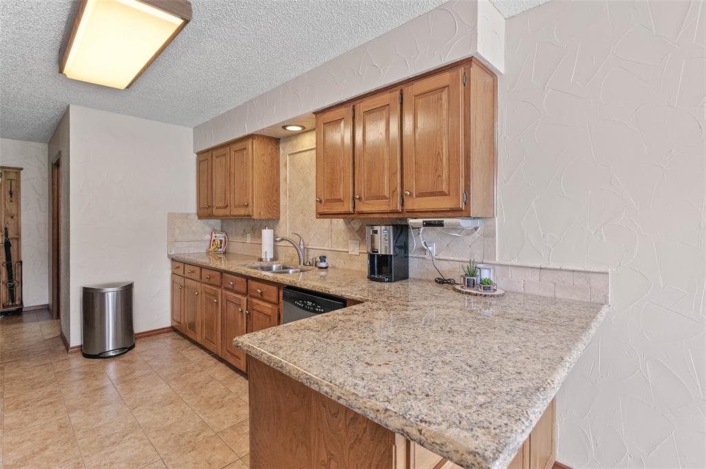 108 Carlin Road Mansfield, TX 76063 - Photo 8 of 40 a kitchen with stainless steel appliances granite countertop wooden cabinets a sink and dishwasher