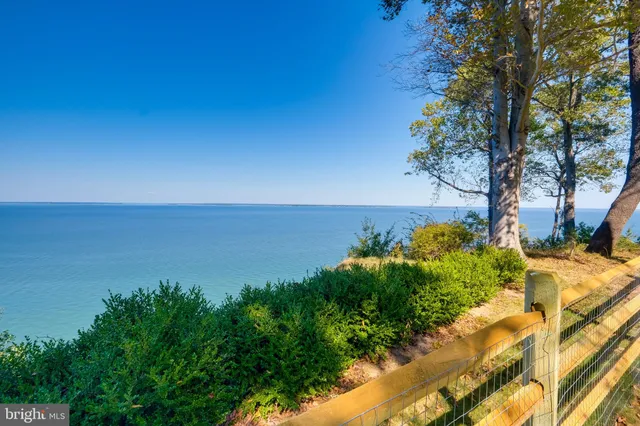 a view of a swimming pool with lawn chairs under an umbrella
