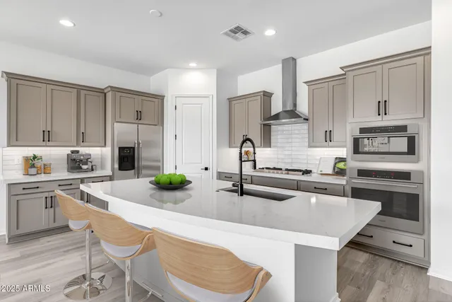 a kitchen with stainless steel appliances granite countertop a white cabinets and wooden floor