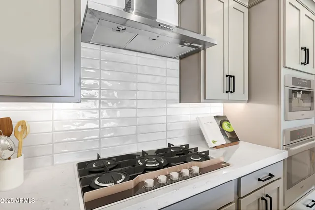 a view of a kitchen with kitchen island wooden floors stainless steel appliances and cabinets