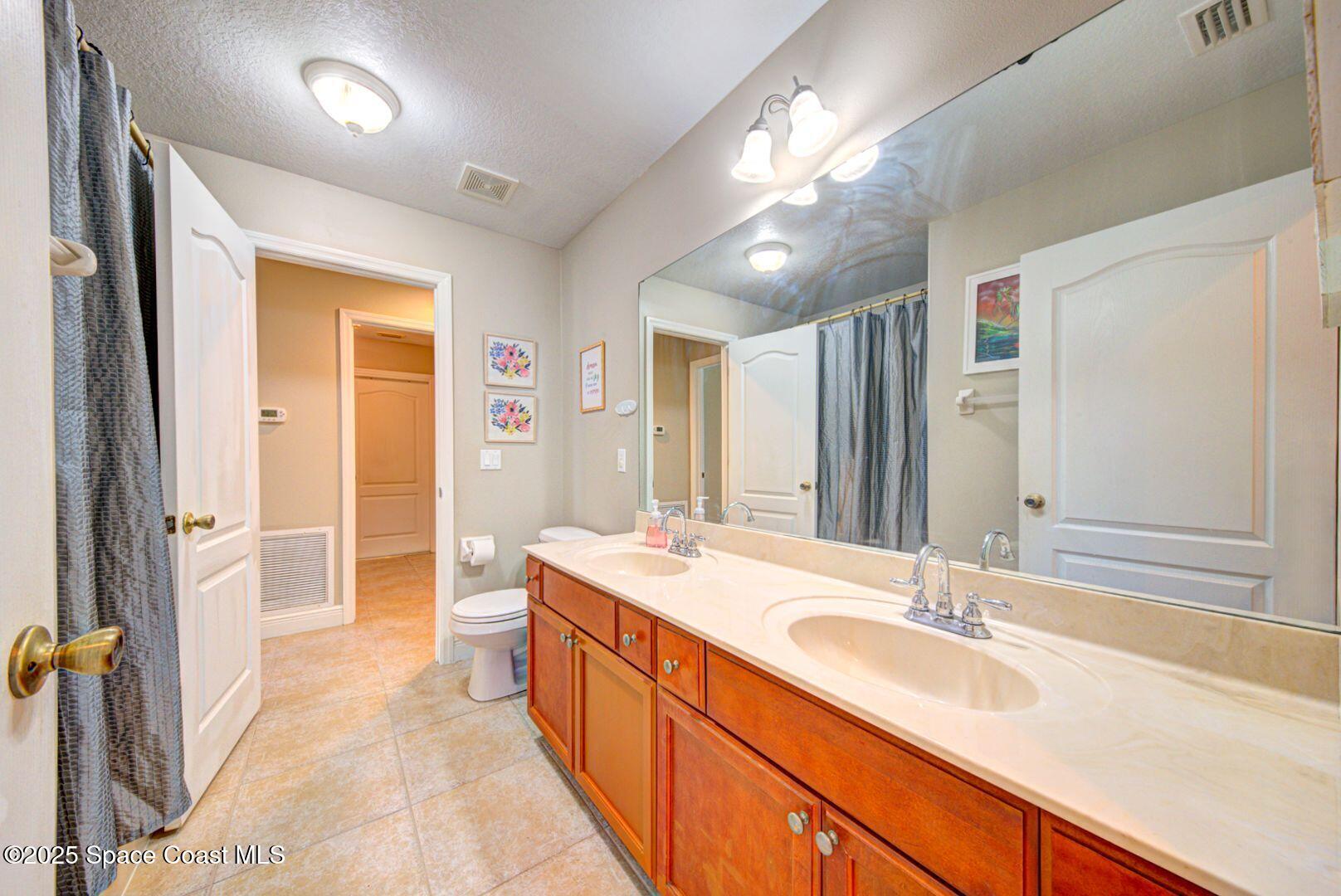 4082 Brantley Circle Rockledge, FL 32955 - Photo 24 of 31 a spacious bathroom with a sink double vanity granite and a large mirror