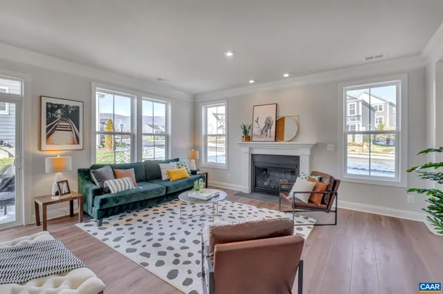 a living room with furniture a fireplace and a large window