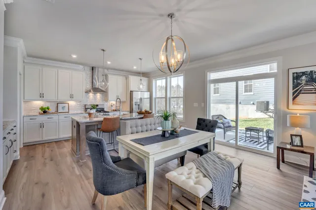 a living room with furniture kitchen view and a large window