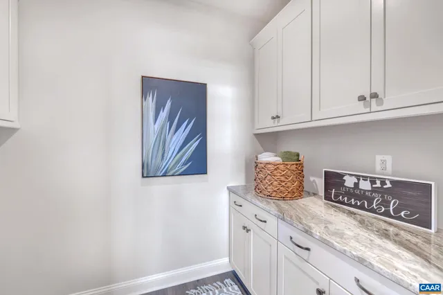 a kitchen with granite countertop white cabinets and stainless steel appliances