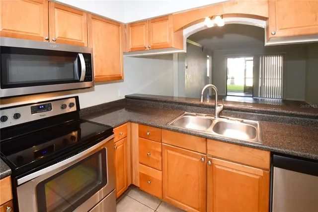 a kitchen with granite countertop white cabinets and stainless steel appliances