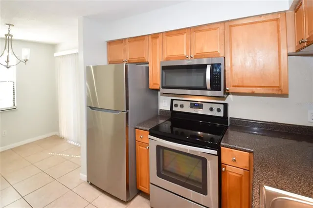 a kitchen with stainless steel appliances granite countertop a refrigerator a sink a stove and dishwasher