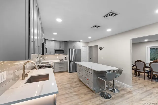 a living room with furniture and a dining table with wooden floor