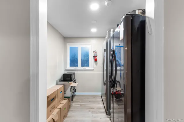 a view of a hallway with closet and a window