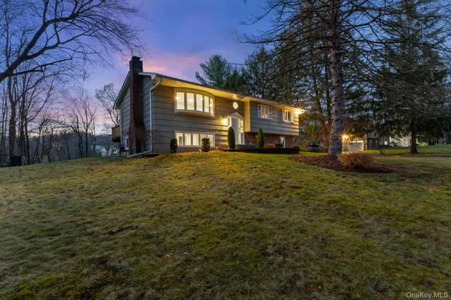 a view of a big house with a big yard and large trees