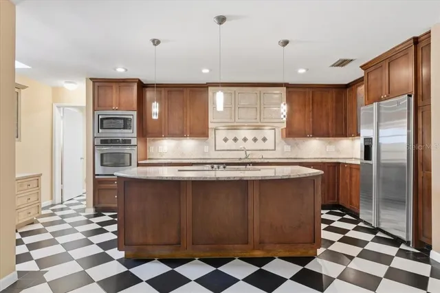 a kitchen with stainless steel appliances granite countertop a sink and cabinets with wooden floor