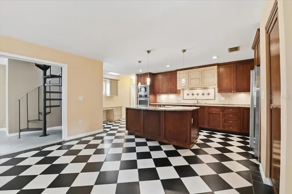 a kitchen with stainless steel appliances kitchen island granite countertop a sink stove and microwave