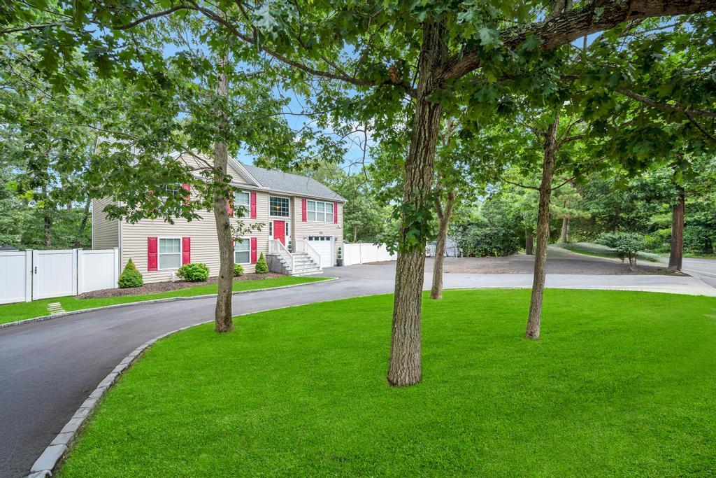 655 Whiskey Road Ridge, NY 11961 - Photo 1 of 1 Bi-level home with a garage, driveway, and a gate