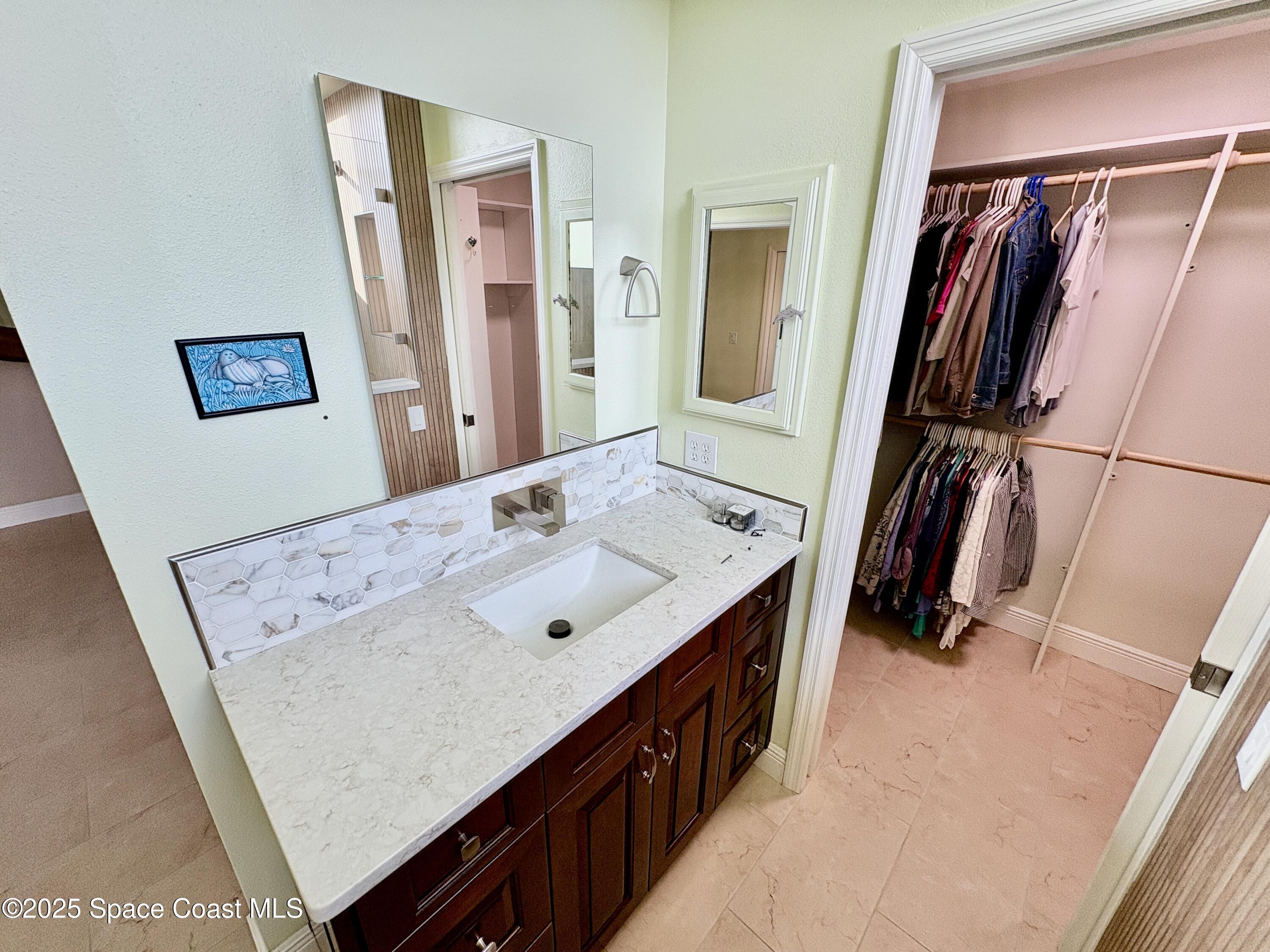 349 Country Walk Street Melbourne, FL 32940 - Photo 11 of 20 a bathroom with a sink a mirror and a shower