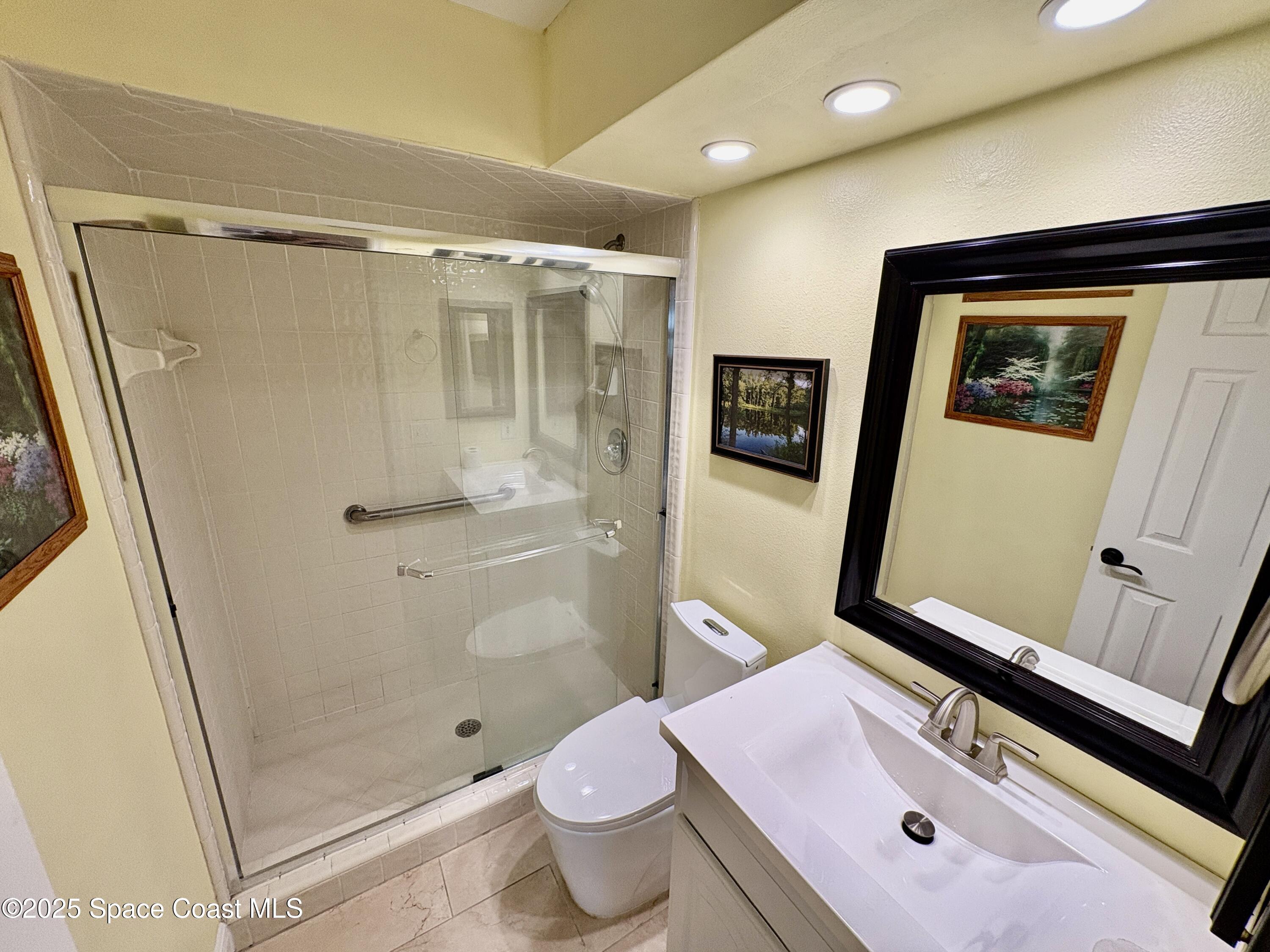 349 Country Walk Street Melbourne, FL 32940 - Photo 14 of 20 a bathroom with a granite countertop sink toilet and shower