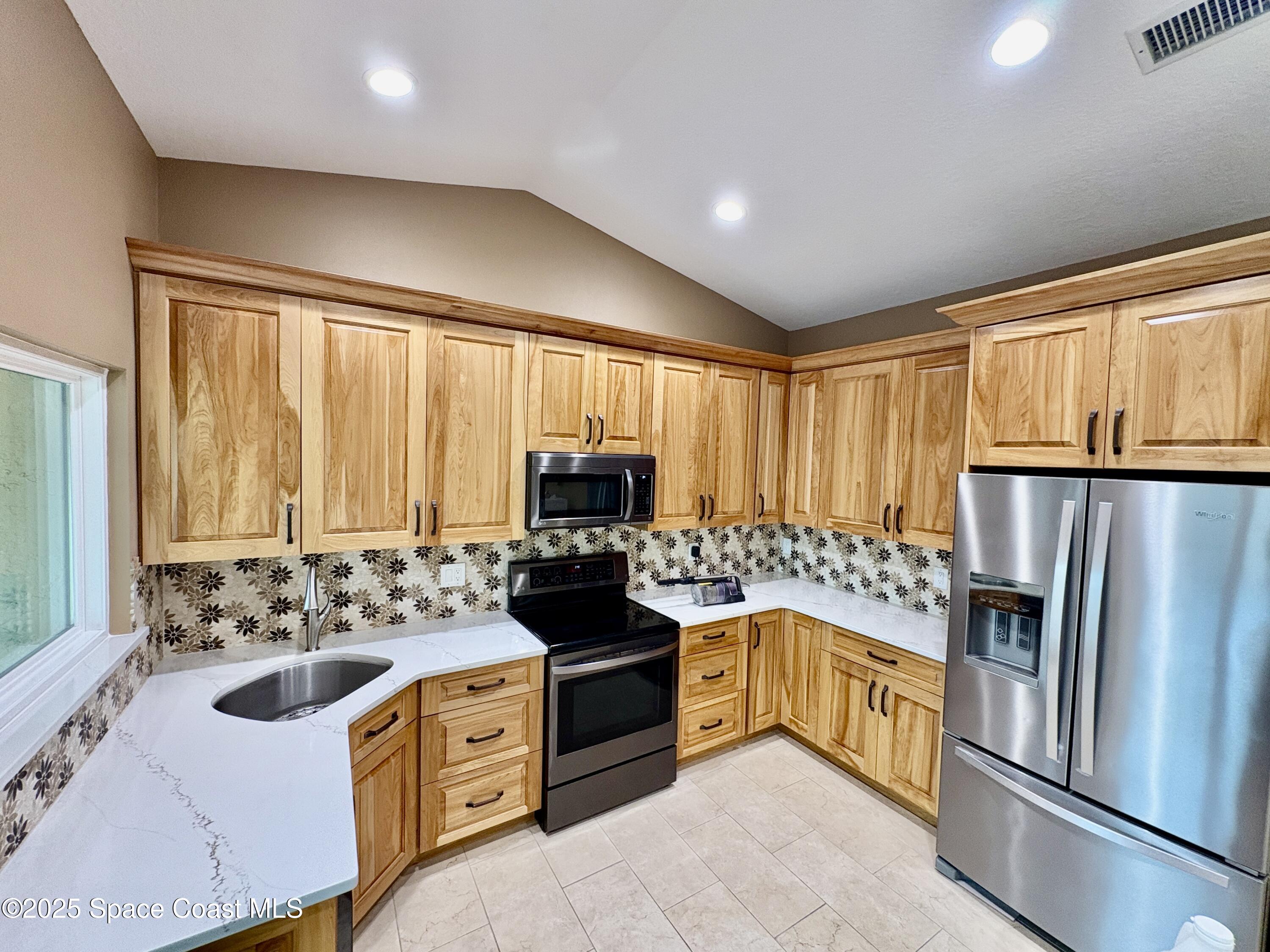349 Country Walk Street Melbourne, FL 32940 - Photo 3 of 20 a kitchen with a stove a sink and a refrigerator
