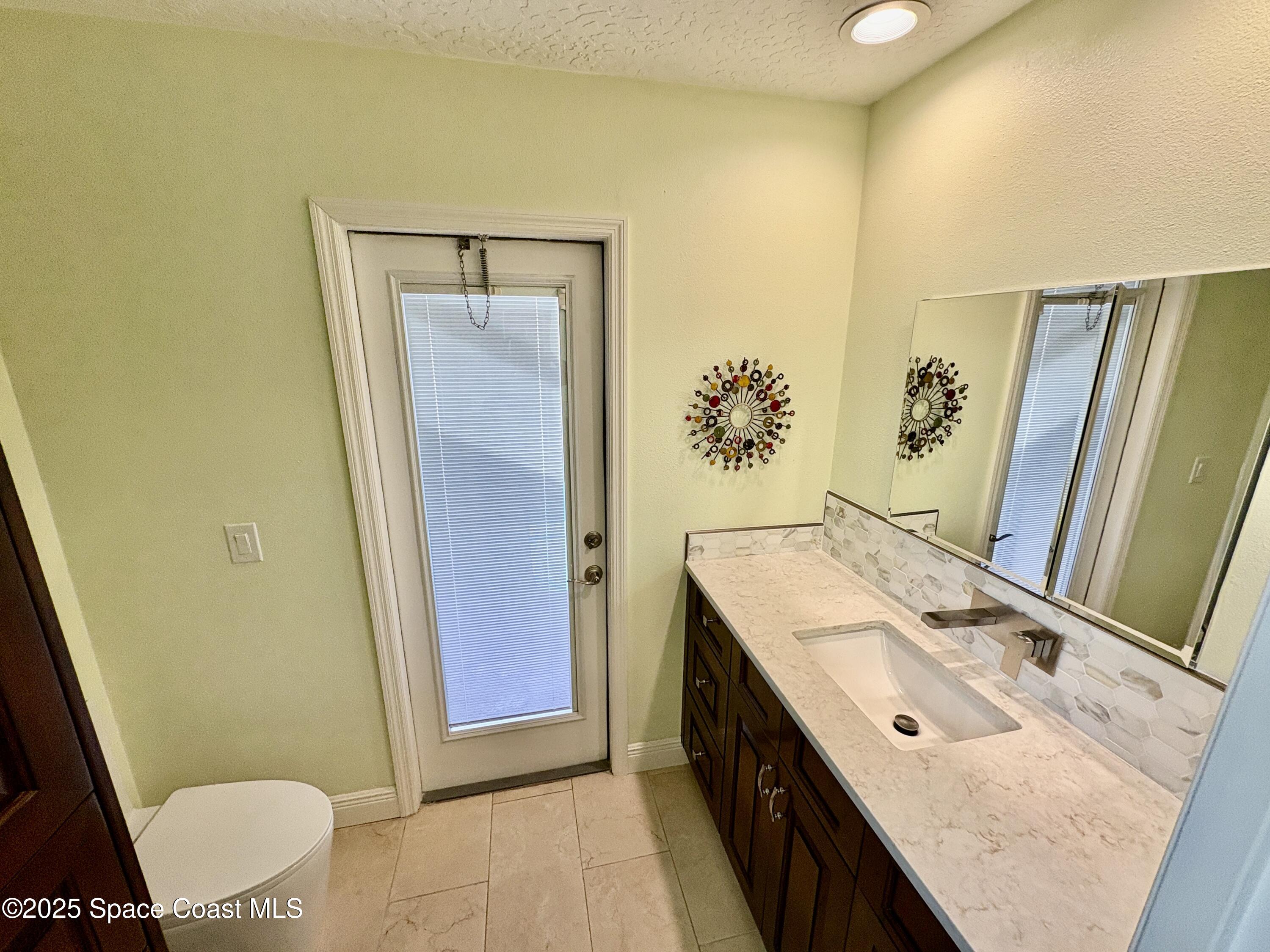 349 Country Walk Street Melbourne, FL 32940 - Photo 10 of 20 a bathroom with a sink a toilet and mirror