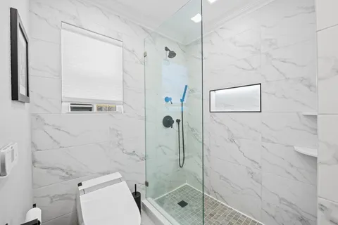 a bathroom with a shower a toilet and a sink