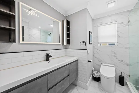 a bathroom with a toilet sink and mirror