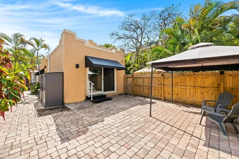 a backyard of a house with sofas table and chairs