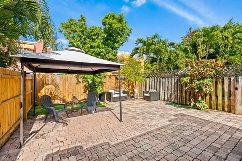 a patio with table and chairs and potted plants