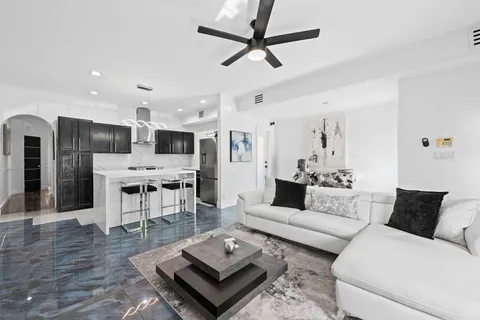 a living room with furniture and kitchen view