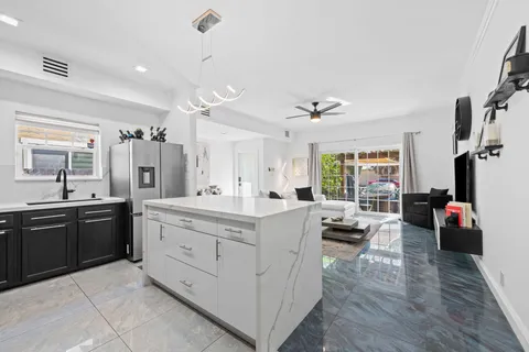 a large white kitchen with a large window a sink and stainless steel appliances
