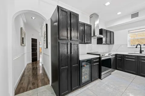 a kitchen with stainless steel appliances granite countertop a refrigerator a sink a stove and oven