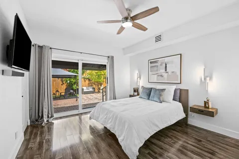 a bedroom with a balcony a bed and a flat screen tv